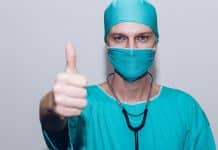 Comment choisir la bonne mutuelle santé ? person in green crew neck long sleeve shirt wearing blue face mask