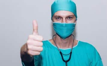 Comment choisir la bonne mutuelle santé ? person in green crew neck long sleeve shirt wearing blue face mask