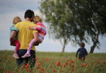 Tout comprendre sur la parentalité : définition, enjeux et accompagnement man carrying to girls on field of red petaled flower